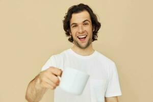 man in a white T-shirt with a mug in hand isolated background photo