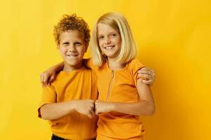 Cute stylish kids in yellow t-shirts standing side by side childhood emotions isolated background photo