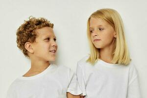 Little boy and girl in white T-shirts are standing next to Lifestyle unaltered photo