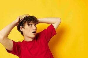 guy with red curly hair in a red t-shirt with a fashion hat yellow background unaltered photo