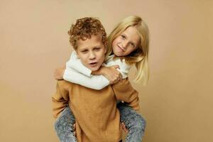 pequeño chico y niña en pie siguiente a posando emociones aislado antecedentes foto