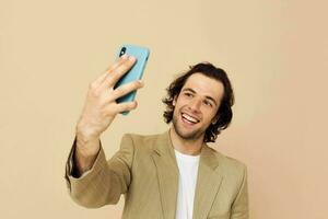 handsome man with a phone in hand beige suit elegant style Lifestyle unaltered photo
