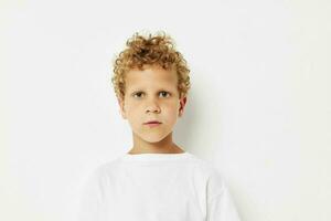 emotional boy with curly hair in a white t-shirt close up photo