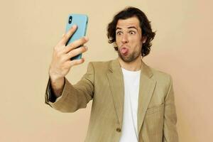 hermoso hombre con un teléfono en mano beige traje elegante estilo estilo de vida inalterado foto