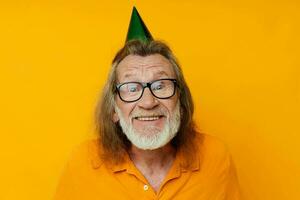 retrato de contento mayor hombre vistiendo lentes verde gorra en su cabeza fiesta emociones inalterado foto