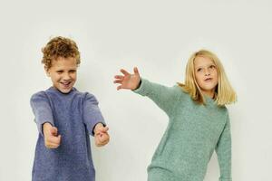 Photo of two children gesticulate with their hands together isolated background