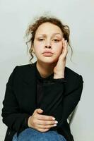 retrato de un joven mujer elegante estilo negro chaqueta de sport posando ligero antecedentes inalterado foto