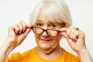 Portrait of an old friendly woman vision problems with glasses light background photo