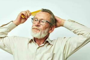 Elderly man combing hair in studio photo