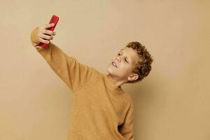 pequeño chico con Rizado pelo rojo teléfono tecnología divertido foto