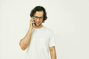 Attractive man in a white T-shirt communication by phone isolated background photo