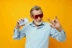 retrato de contento mayor hombre azul camisas con lentes toma un selfie inalterado foto