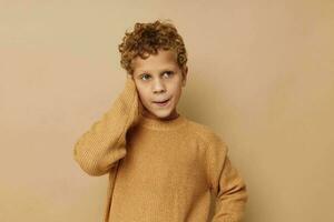 curly boy talking on the phone posing beige background photo