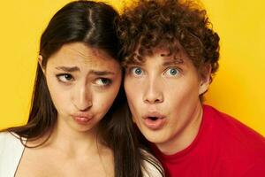 young boy and girl together posing emotions close-up yellow background unaltered photo