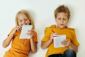 cheerful children emotions drawing together notepad and pencils light background unaltered photo