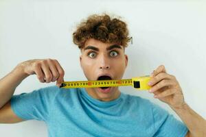 handsome young man emotions grimace measuring tape Lifestyle unaltered photo