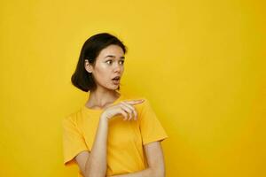 optimista joven mujer en amarillo camiseta posando Moda estilo de vida inalterado foto