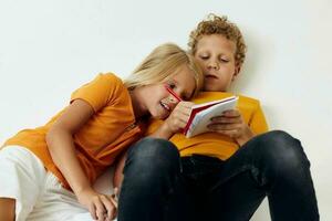 Boy and girl emotions drawing together notepad and pencils isolated background unaltered photo