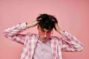 portrait of a young man pink glasses checkered jacket fashion posing pink background unaltered photo