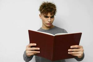 joven chico con libro aprendizaje educación posando foto