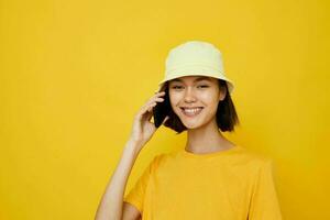 beautiful girl yellow t-shirt and Hat summer style with phone Lifestyle unaltered photo