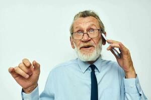 foto de retirado antiguo hombre en un camisa con un Corbata con un teléfono tecnología ligero antecedentes