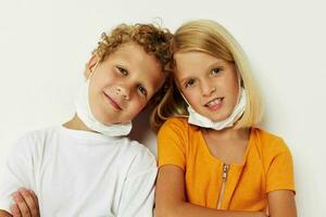 Portrait of cute children fun medical mask stand side by side close-up lifestyle unaltered photo