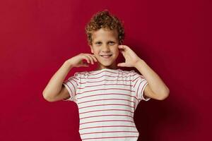 Cheerful boy in casual clothes posing emotions red background photo