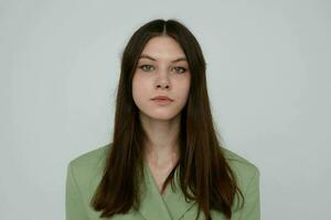 brunette in green jacket posing emotions light background photo