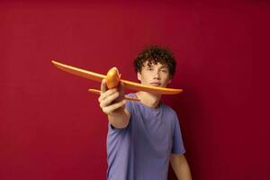 kinky guy with toy airplane entertainment red background unaltered photo