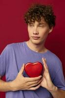 young man heart shaped gift red background photo
