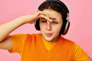 cheerful woman listening to music with headphones orange sweater emotions fun isolated backgrounds unaltered photo