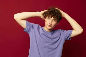 teenager in purple t-shirts posing emotions isolated background unaltered with a cap on his head photo