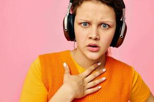 cheerful woman in an orange sweater headphones music entertainment cropped view unaltered photo