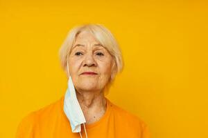 smiling elderly woman in yellow t-shirts in medical masks close-up emotions photo