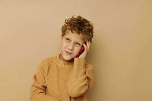 Cheerful boy talking on the phone on a beige background photo