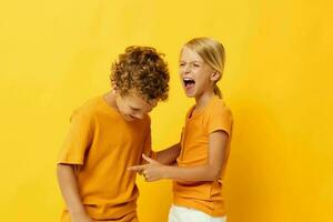 Small children in yellow t-shirts standing side by side childhood emotions isolated background unaltered photo