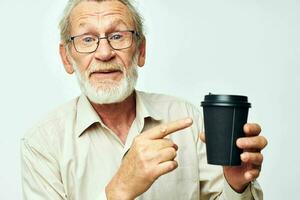 Photo of retired old man in a shirt and glasses a black glass isolated background