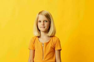 cute little girl with blond hair posing yellow background photo