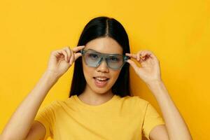 attractive asian woman glasses posing yellow background photo