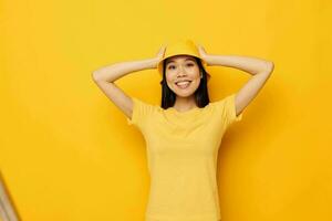 mujer con asiático apariencia en un amarillo camiseta y sombrero posando emociones monocromo Disparo foto