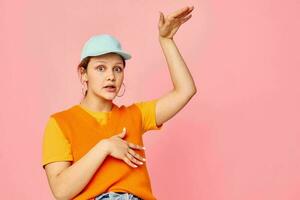 funny girl in an orange sweater in blue caps hand gesture Lifestyle unaltered photo