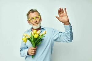 elderly man in a blue shirt with a bouquet of flowers cropped view photo