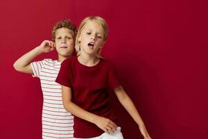 Boy and girl emotions stand side by side in everyday clothes on colored background unaltered photo