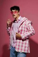 portrait of a young man in pink glasses pink blazer posing studio isolated background unaltered photo