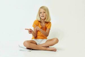 pretty girl with blond hair sitting on the floor isolated light background emotions photo