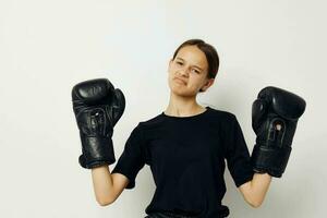 athletic woman in black sports uniform boxing gloves posing isolated background photo