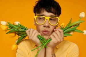pretty man with a fashionable hairstyle in yellow shirts with flowers holiday unaltered photo