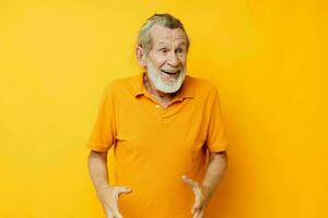Senior grey-haired man yellow shirt posing emotions isolated background photo