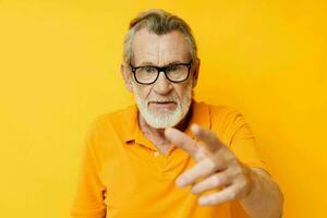 Portrait of happy senior man wearing glasses yellow shirt posing unaltered photo